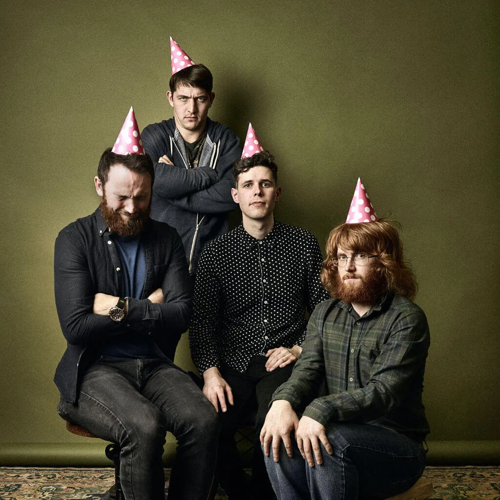 The Temporary album cover: the four members of Trookers in pink party hats, none of them enjoying the party